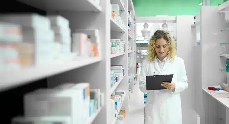farmacéutico revisando inventario en laboratorio, contexto de gestión de cartera con EPS en sector farmacéutico - Profitline