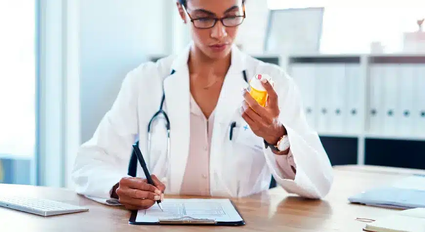 Profesional revisando medicamentos y documentos para la radicación de facturas farmacéuticas - Profitline